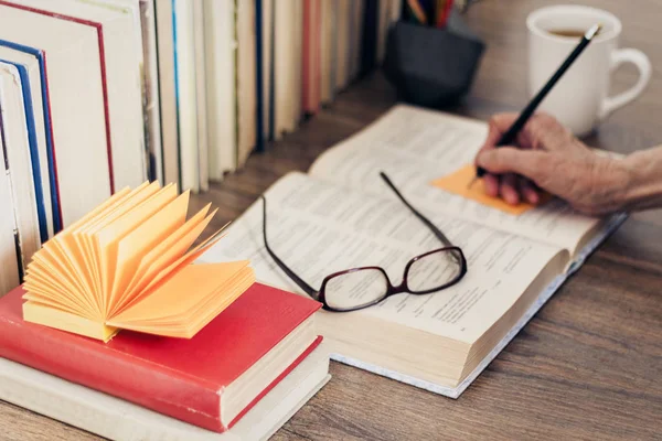 Pila de libros educación fondo, mano femenina hace notas nea — Foto de Stock