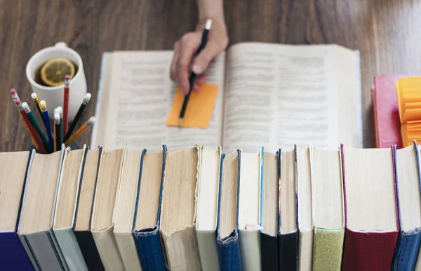 Egy halom könyv oktatási háttér, női kéz jegyzetel nea — Stock Fotó