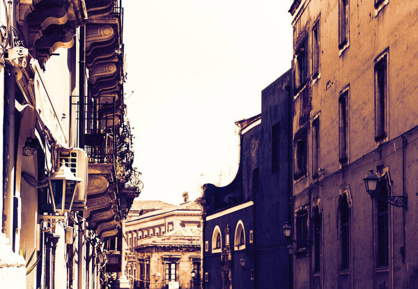 Traditional architecture of Sicily in Italy, typical street of Catania, facade of old buildings on sunset