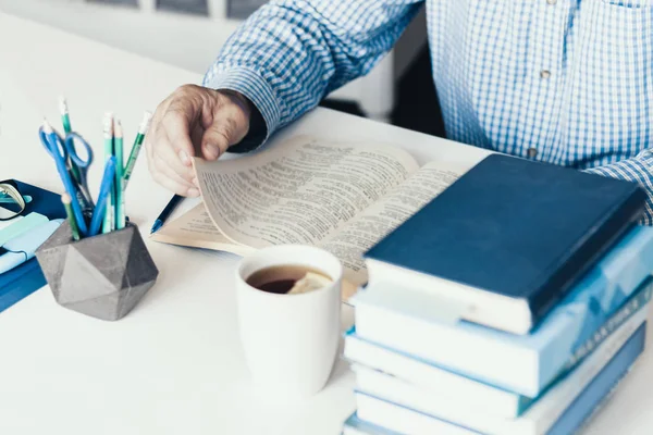 Hombre de mediana edad en camisa azul libro de lectura en la moderna y elegante varita — Foto de Stock