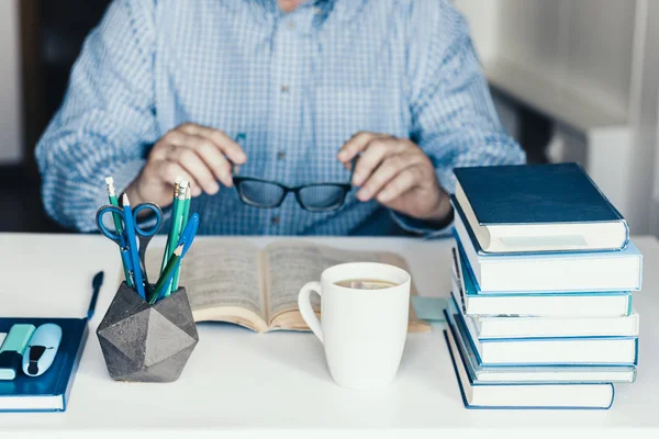 Hombre de mediana edad en camisa azul libro de lectura en la moderna y elegante varita — Foto de Stock