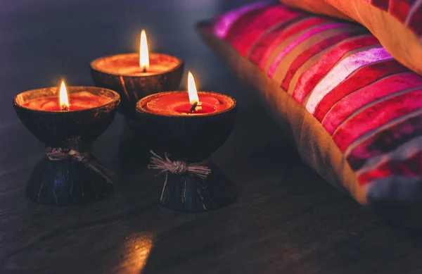 Queimando velas de aroma de spa em casca de coco e travesseiros de borgonha — Fotografia de Stock