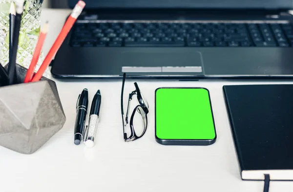 Smartphone tela verde, laptop, notebook, lápis no suporte e — Fotografia de Stock
