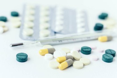 İlaç hapları ya da kapsüller beyaz arka planda su topladı