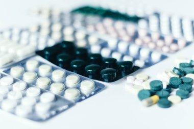 İlaç hapları ya da kapsüller beyaz arka planda su topladı