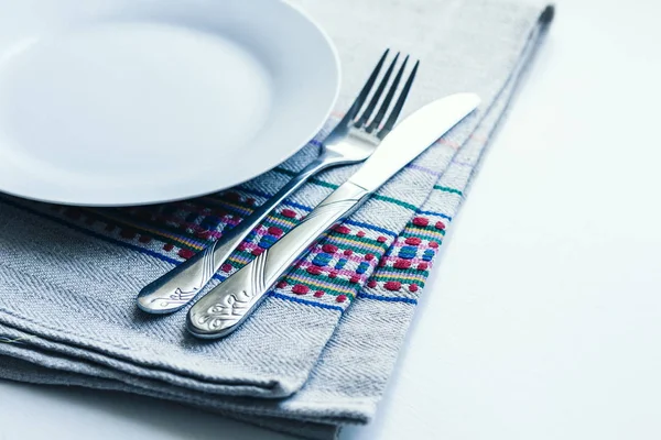 Накрытие стола на ужин: белая тарелка, вилка, нож на воу — стоковое фото
