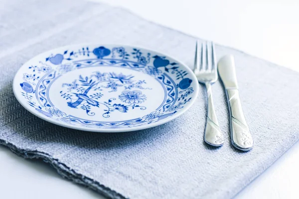 Tafelschikking voor het diner: een witte plaat, een vork, een mes op een wo — Stockfoto
