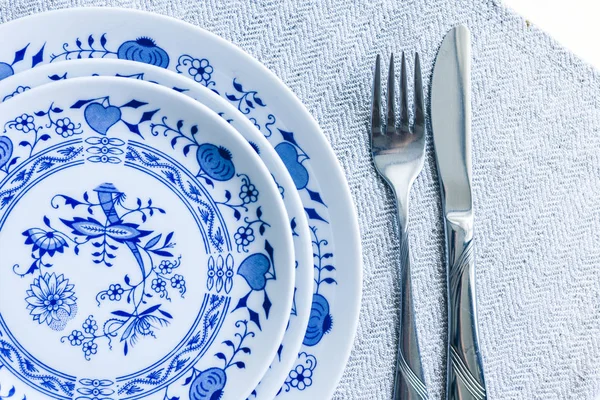 Tafelschikking voor het diner: een witte plaat, een vork, een mes op een wo — Stockfoto