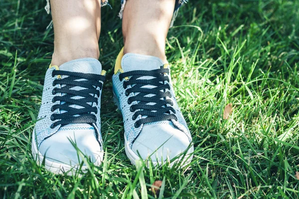 Ung kvinna ben i sport skor sneakers av blå mocka, sitter — Stockfoto