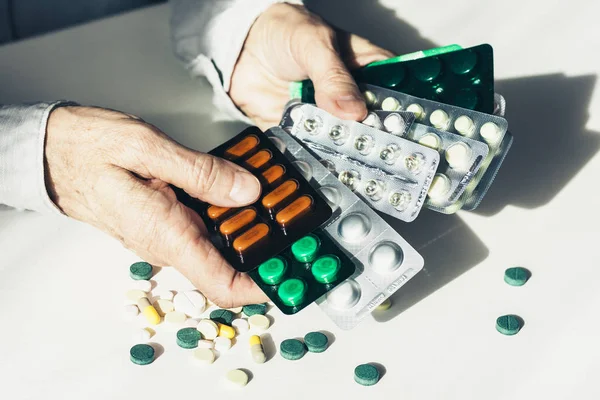 Léky pilulky nebo kapsle v blistru s rukou staré ženy o — Stock fotografie