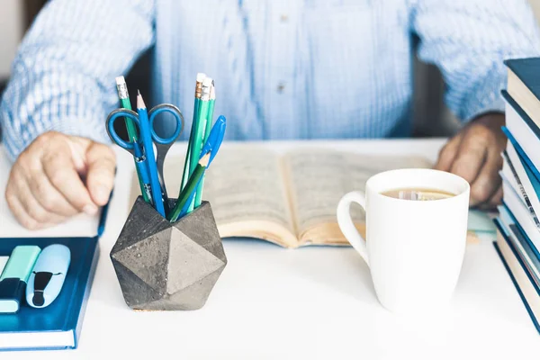 Libro de lectura del hombre en el lugar de trabajo elegante moderno con la oficina suppli — Foto de Stock