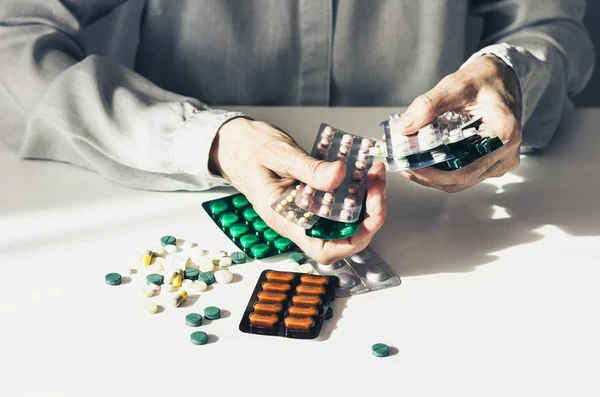 Léky pilulky nebo kapsle v blistru s rukou staré ženy o — Stock fotografie