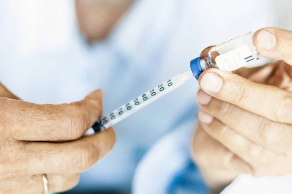 Honhand med en medicinsk spruta och flaska med insulin för d — Stockfoto