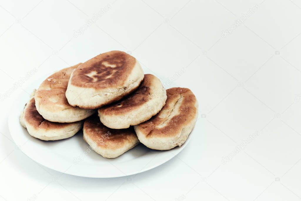 Fried cakes with potato and beans on white table background .
