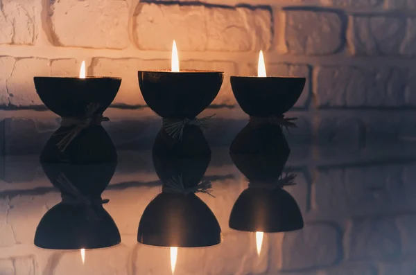 Brandende spa aroma kaarsen in kokosnoot schil op een glazen witte tafel — Stockfoto
