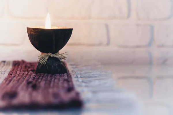 Queimando velas de aroma de spa em casca de coco em um multicol de malha — Fotografia de Stock