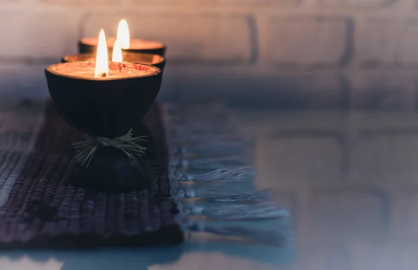 Καμένα κεριά αρώματος spa σε κέλυφος καρύδας σε ένα πλεκτό multicol — Φωτογραφία Αρχείου