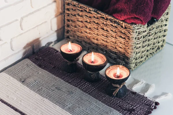 Burning spa aroma candle in coconut shell on a knitted multicolo — ストック写真