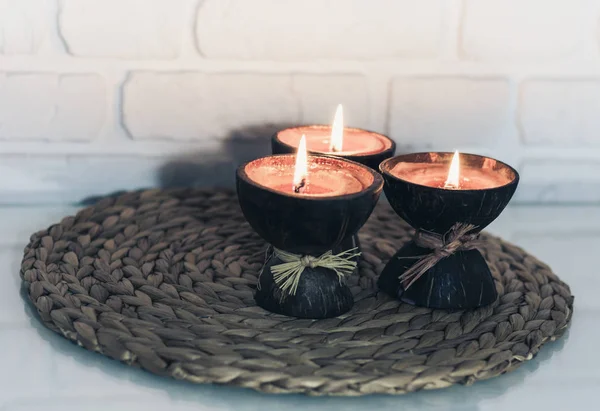 Burning spa aroma candles in coconut shell on wicker stand on a — Stock Photo, Image