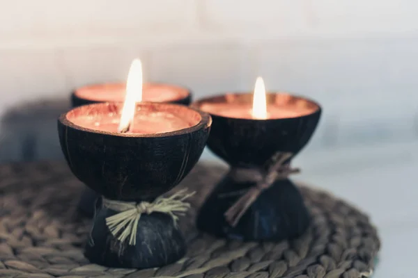 Burning spa aroma candles in coconut shell on wicker stand on a — ストック写真