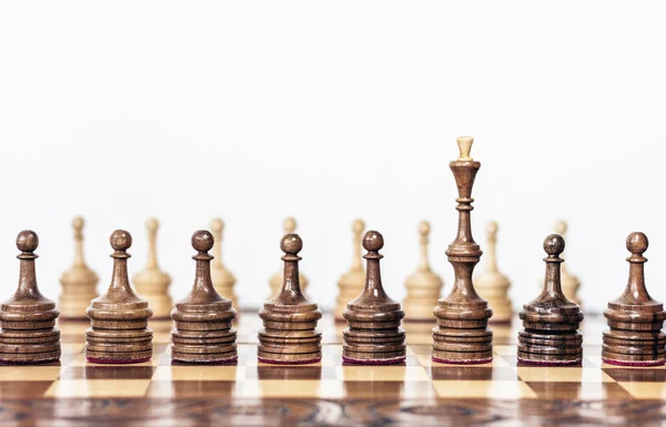 Dřevěné šachové figurky na šachovnici, černá královna a bílí pěšáci — Stock fotografie