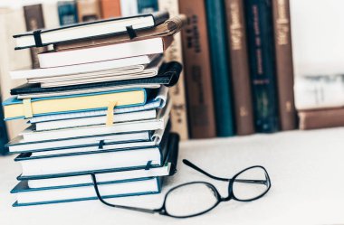 Defter yığını, bir sürü kitap ve ders kitabı, kopyaları olan gözlük.