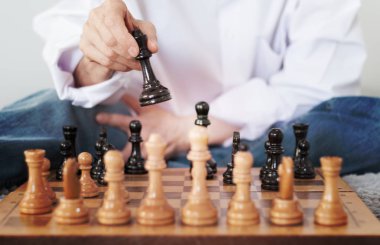 Strateji konsepti, satranç oynayan bir kadının eli.