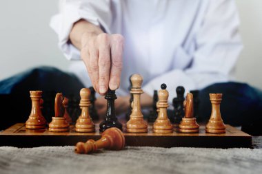 Strateji konsepti, satranç oynayan bir kadının eli.