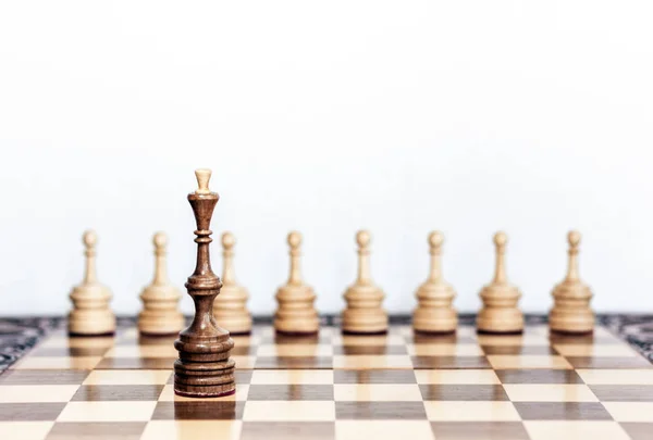 Дерев'яні шахові фігури на шахівниці, чорна королева і білі пішаки — стокове фото