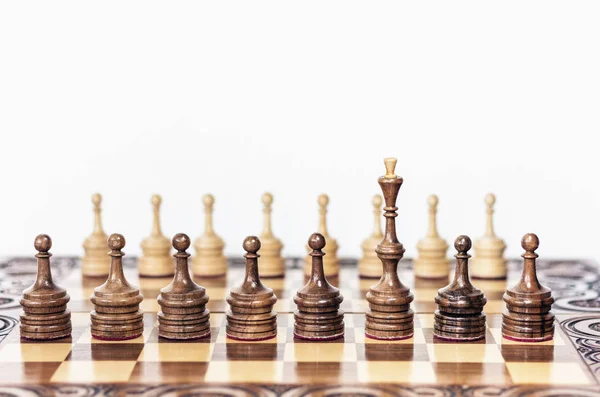Дерев'яні шахові фігури на шахівниці, чорна королева і білі пішаки — стокове фото