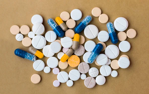 Egy halom színes pirula, gyógyszerészeti gyógyszer tabletták és sapkák — Stock Fotó
