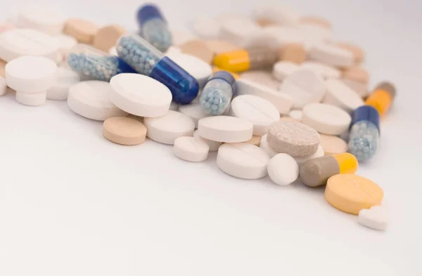 Куча разноцветных таблеток в форме сердца, таблеток и колпачков — стоковое фото