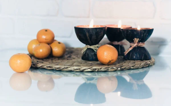 Queimando velas de aroma de spa em casca de coco, tangerinas em vime — Fotografia de Stock