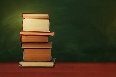 Okula dönüyorum, içi boş yeşil okul tahtasıyla dolu bir yığın kitap.