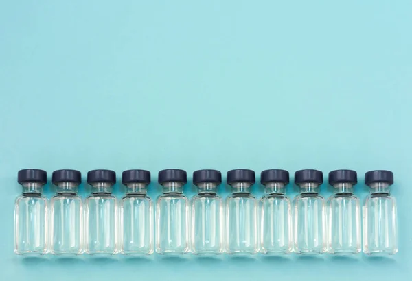 Medicamento em frascos para injetáveis, pronto para injeção de vacina no fundo azul — Fotografia de Stock