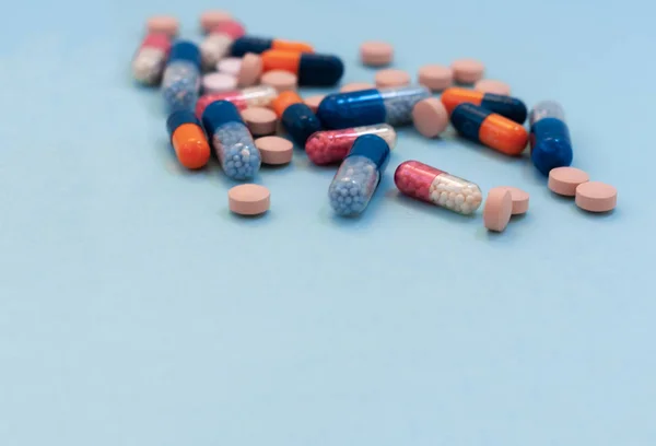 Куча красочных таблеток, таблеток, капсул на синем фоне. Доктор — стоковое фото