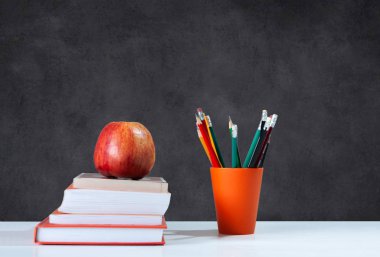 Okula geri döndüm, turuncu kalem tutacağı, beyazla ilgili bir yığın kitap.