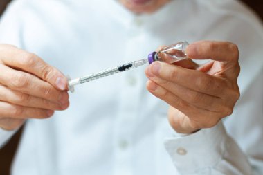 Doktor beyaz ameliyat elbisesi ve mavi maske takıyor.