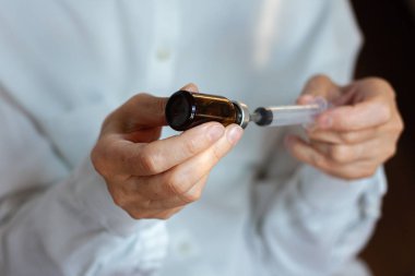 Doktor beyaz ameliyat elbisesi ve mavi maske takıyor.