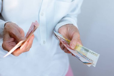 Kadın eli bir paket avroya uzanıyor. Yakından, finans otobüsü.