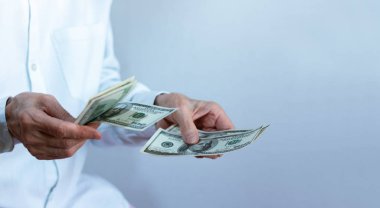 Kadın eli, bizden bir deste dolar uzatıyor. Yaklaş, Finan.