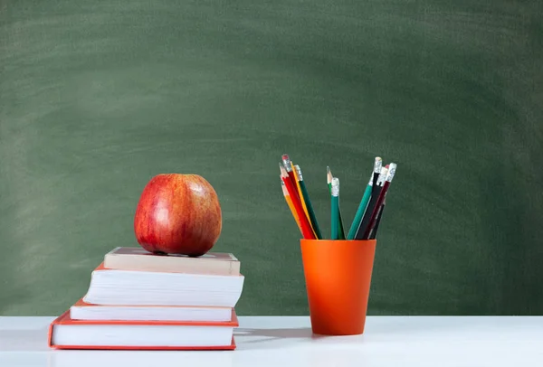 学校に戻る,オレンジの鉛筆ホルダー,白いta上の本のスタック — ストック写真