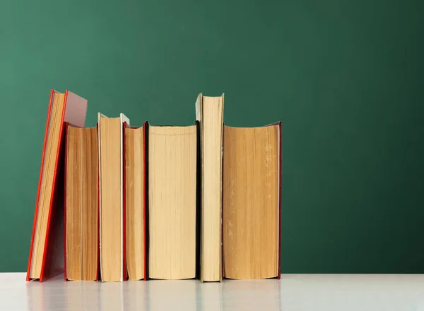 Back to school, pile of books with empty green school board back — Stock Photo, Image