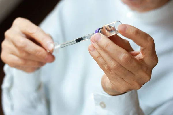 Doktor beyaz ameliyat elbisesi ve mavi maske takıyor.
