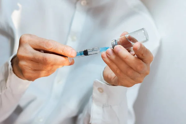 Doktor beyaz ameliyat elbisesi ve mavi maske takıyor.