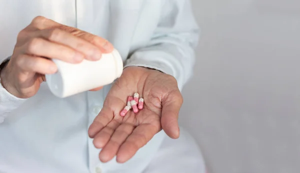 Female hand close up holding a medicine, elderly woman hands wit