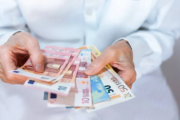 Female woman hand holds out a pack of euro close up, finance bus