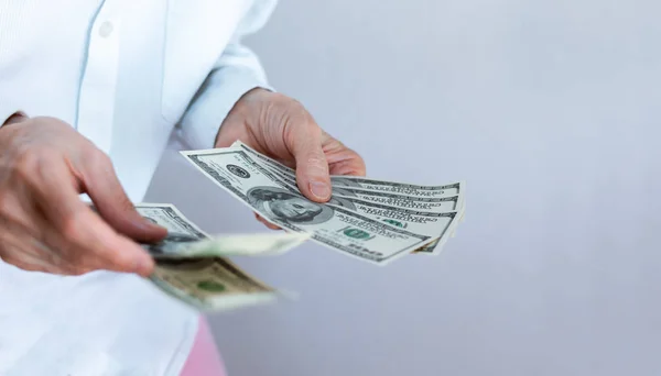 Female woman hand holds out a pack of us dollars close up, finan