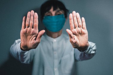 Koronavirüs karantinası ve hava kirliliği pm2.5 kavramını durdurun. Uzamış koluyla korunmak için solunum maskesi takan hasta yaşlı bir kadın. Wuhan, Çin salgını virüs belirtileri.