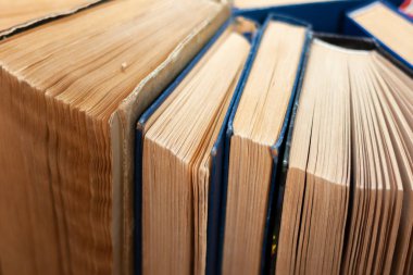 Kitapçıda ya da kütüphanede eski ve iyi kullanılmış kitaplar ya da ders kitapları. Bir sürü kitap yığını. Ahşap masa manzaralı sert ciltli kitaplar. Kopya alanı ile okula geri dön